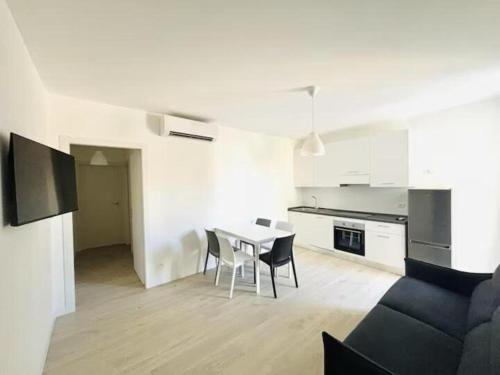 a white kitchen with a table and chairs in a room at Villa Dune - Centrale - Immobil Relax in Lido di Jesolo