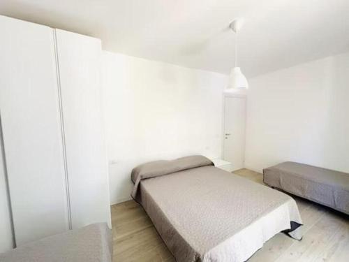a bedroom with two beds in a white room at Villa Dune - Centrale - Immobil Relax in Lido di Jesolo