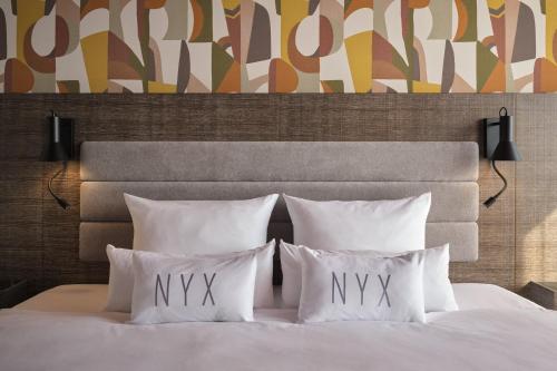 a bedroom with a white bed with four pillows at NYX Hotel Berlin Köpenick by Leonardo Hotels in Berlin