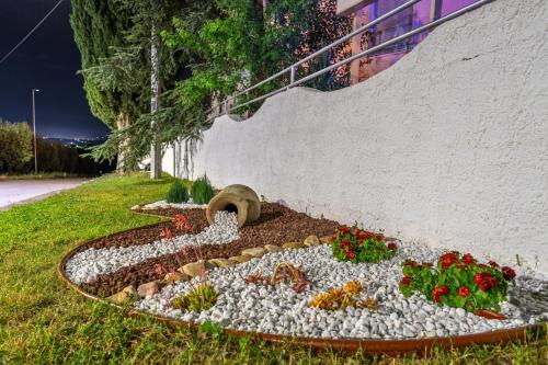 a garden with flowers in a flower bed next to a wall at Villa Yucca - B&B and Glamping in Torano Nuovo