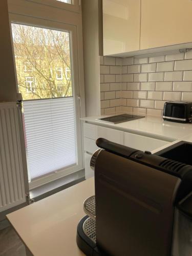 a kitchen with a couch and a window in it at Altbaucharme Deluxe mit Balkon in Kiel
