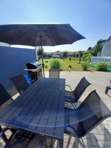 a blue picnic table with an umbrella and chairs at Prázdninový dům Sorada in Rohatec