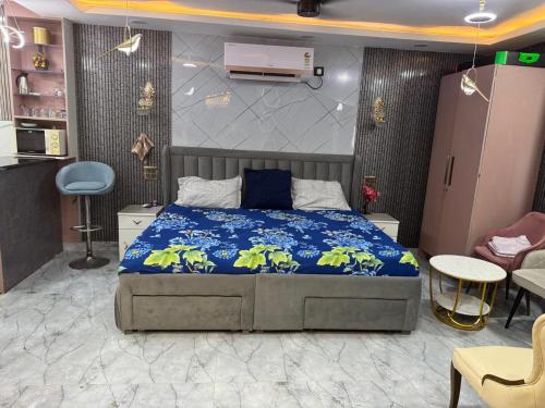 a bedroom with a bed with a blue comforter at Urban Nest in Dehradun