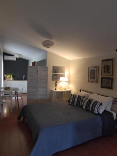 a bedroom with a large bed and a kitchen at Cosy Garden Bungalow in Messini