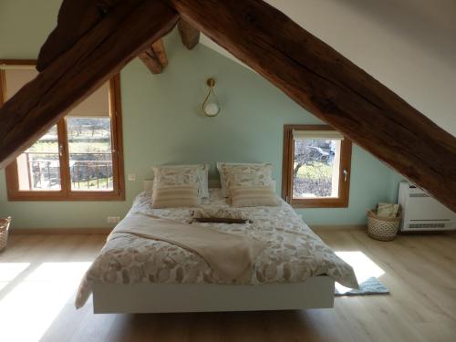 une chambre avec un grand lit dans un grenier dans l'établissement La grange de Babelli, à Valdeblore