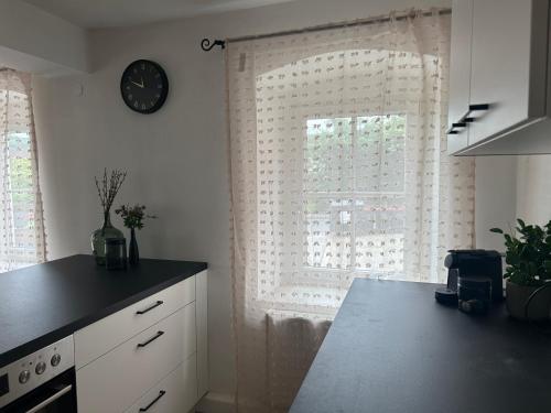 a kitchen with a window with a clock on the wall at FarawayHomes Studio Schwertberg #1 in Schwertberg