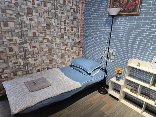 a room with a small bed in a brick wall at 211 Spacious studio with breezy fan full amenities with free Wi-Fi in Bangkok
