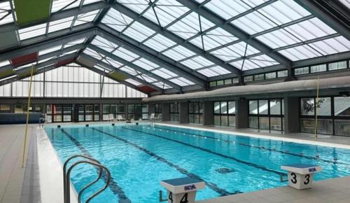 une grande piscine avec un grand plafond en verre dans l'établissement La grange de Babelli, à Valdeblore