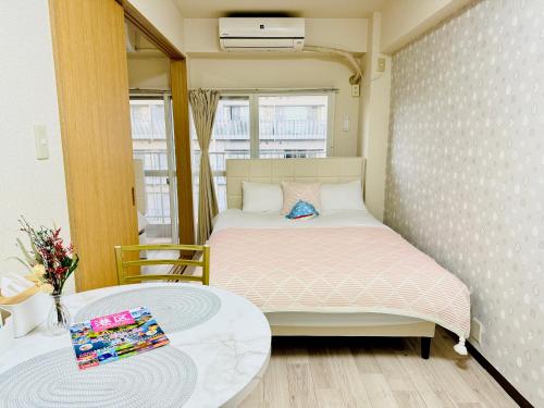 a small bedroom with a bed and a table at 高輪ー703 in Tokyo