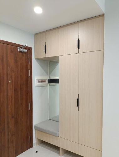 a large wooden cabinet with a bench in a room at The Emerald Golf View in Thuan An