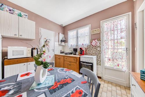 une cuisine avec une table et un vase dans l'établissement Villa Récompense Côte Atlantique n3, à Soulac-sur-Mer