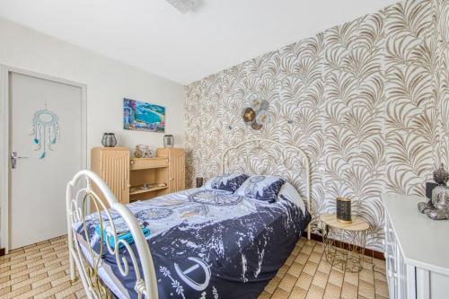 une chambre avec un lit et un mur dans l'établissement Villa Récompense Côte Atlantique n3, à Soulac-sur-Mer