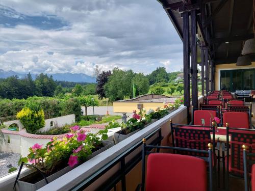 a balcony with chairs and flowers on a building at Vitalhotel Marienhof in Velden am Wörthersee