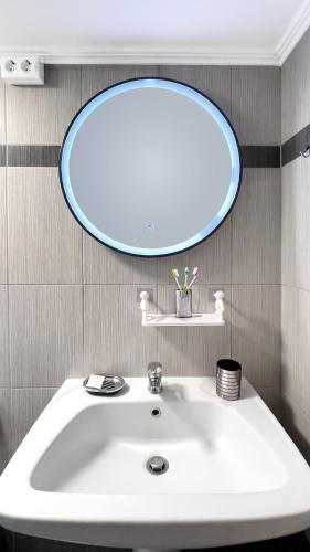 a bathroom with a white sink and a mirror at Rona Vista Suites amazing seaview 1 in Polykhrono