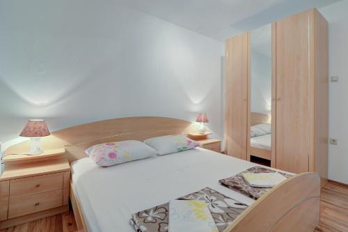 a bedroom with a bed with two pillows on it at Seabreeze Apartments with Shared Jacuzzi in Senj
