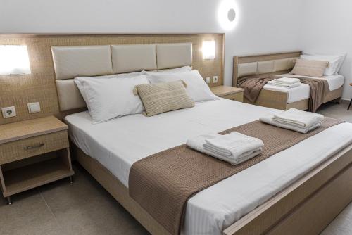 een slaapkamer met een groot bed met twee handdoeken erop bij Porto Psakoudia in Psakoudia