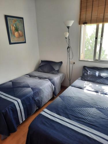 a bedroom with two beds and a window at Apto a 2 minutos de playa. in Fuengirola