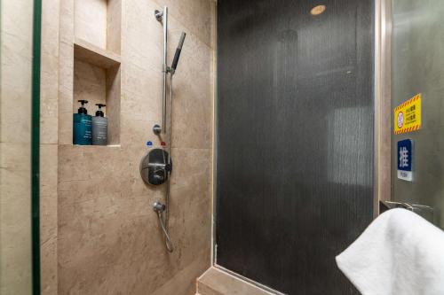 a shower with a glass door in a bathroom at Bulgari Serviced Residences Guangzhou in Guangzhou
