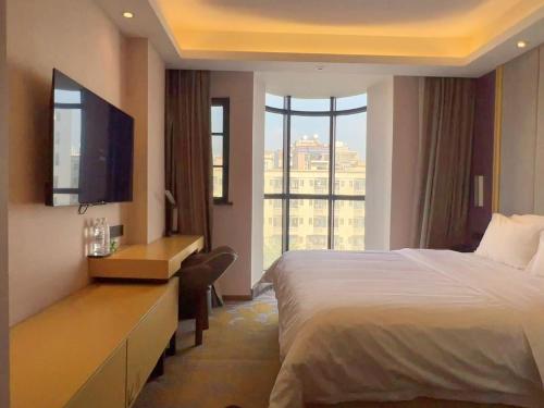 a hotel room with a bed and a large window at Lavande Hotel Shenzhen International Convention and Exhibition Center Fuhai West Subway Station in Shenzhen