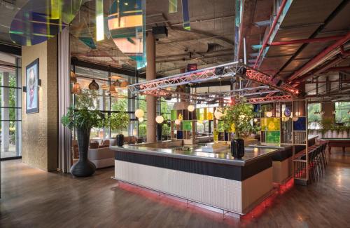 a bar in a restaurant with a counter at NYX Hotel Berlin Köpenick by Leonardo Hotels in Berlin