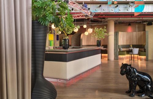 a lobby with a bar with a black dog statue at NYX Hotel Berlin Köpenick by Leonardo Hotels in Berlin