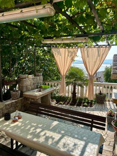 a patio with a table and a pergola at Apartment Laura in Senj