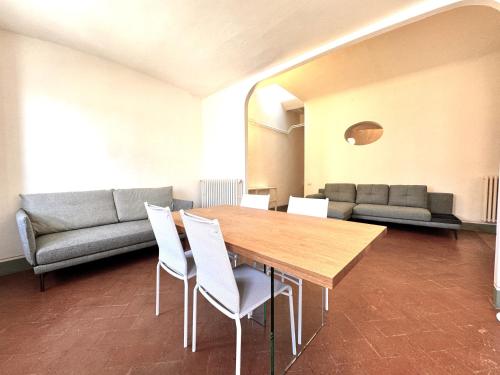锡耶纳Pellegrini- Behind the Cathedral的有桌子、椅子和沙发的房间