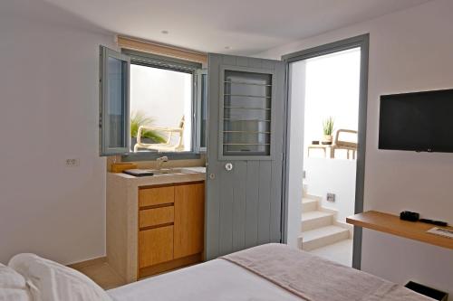 a bedroom with a bed and a sink and a television at La Maltese Central in Naousa