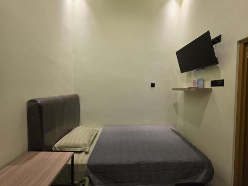 AlastuwoにあるGreen Living Homeのベッドと壁にテレビが掛かった寝室