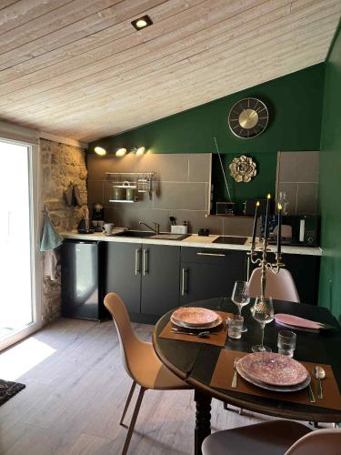 une cuisine et une salle à manger avec une table et des chaises dans l'établissement Gîte de charme romantique avec Spa privatif l'Echappée bulles, à Chambon