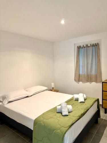 a bedroom with a bed with two towels on it at Maison avec jardin et proche mer in Propriano