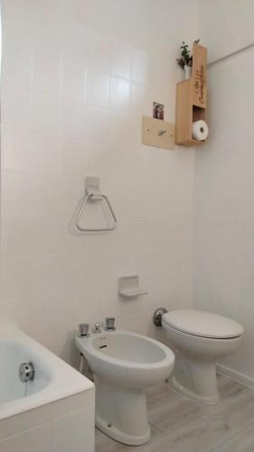 a white bathroom with a toilet and a sink at Vesto VISTA in Marone