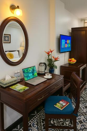 a desk with a laptop and a mirror in a room at Hanoi Siva Luxury Hotel & Travel in Hanoi