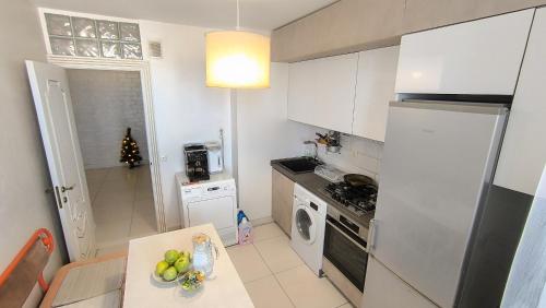 a kitchen with a refrigerator and a table with fruit on it at Kомната под ключ - Bedroom - Cameră la cheie in Chişinău