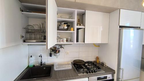 a kitchen with white cabinets and a stove top oven at Kомната под ключ - Bedroom - Cameră la cheie in Chişinău