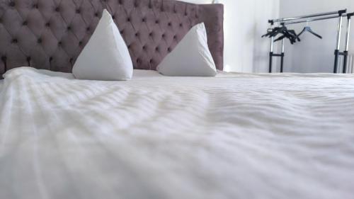 a bed with white sheets and pillows on it at Kомната под ключ - Bedroom - Cameră la cheie in Chişinău