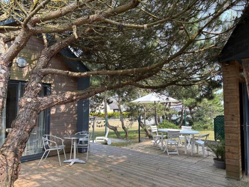 a patio with a table and chairs and an umbrella at La Cambuse in Saint-Germain-sur-Ay
