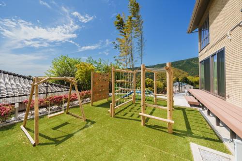 a playground in a backyard with a bench and grass at Villa atami in Atami