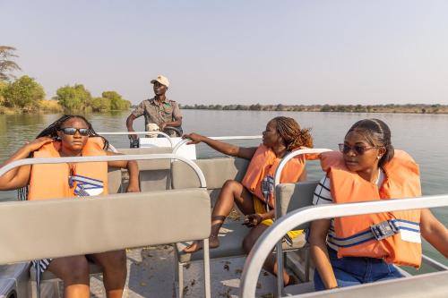 a group of people on a boat on the water at Rain Tree Camp in Chunga