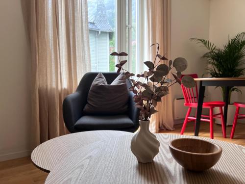 a vase with flowers in it on a table in a living room at Blue House Odda in Odda