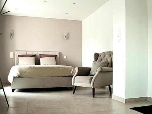 une chambre avec un lit, un canapé et une chaise dans l'établissement Hôtel-Restaurant Belle'man, à Longevelle-sur-Doubs