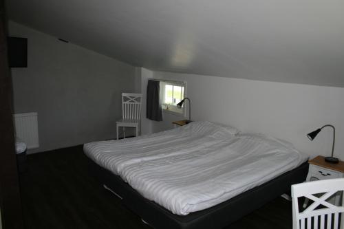 a white bed in a room with a window at Visby Innerstad Lägenheter & Rum in Visby