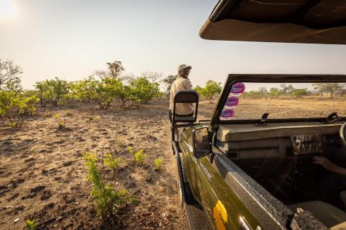 a man standing in the back of a vehicle looking out of the window at Rain Tree Camp in Chunga