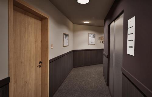 Un pasillo con una puerta y una fila de puestos. en Hotel L'Ecrin Blanc by Odalys, en La Rosière