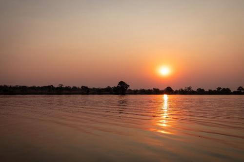a sunset over a body of water at Rain Tree Camp in Chunga