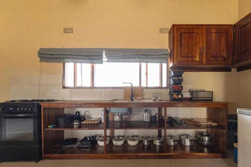a kitchen with a shelf with pots and pans at Rain Tree Camp in Chunga