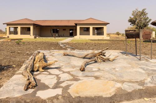 a house with a pile of logs in front of it at Rain Tree Camp in Chunga