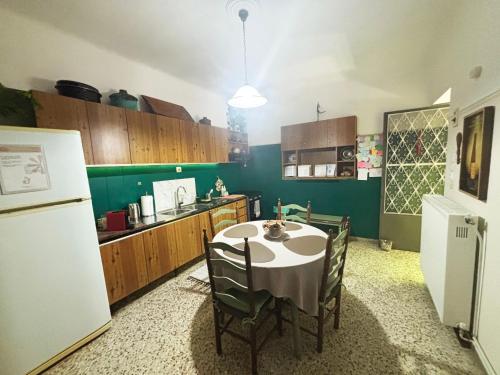 a kitchen with a table with chairs and a refrigerator at The Local Pin House - Ευρύχωρη μονοκατοικία, Λαμία in Lamía
