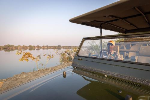 a man sitting in the back of a jeep at Rain Tree Camp in Chunga