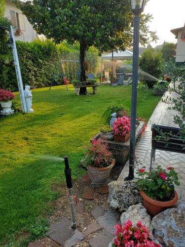 a garden with potted plants and a swing yard at Casacobelli in Monzambano